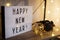 Lightbox with happy new year text on the table with vintage camera and led lights