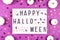 Lightbox with the inscription Happy Halloween on a purple background with confetti