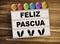 Lightbox or light box with easter eggs and spanish words for happy easter - feliz pascua on a wooden background