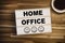 Lightbox or light box with message Homeoffice on a wooden table with cup of coffee