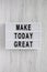 Lightbox with `Make today great` words on a white wooden background, top view. Overhead, from above. Flat lay. Close-up