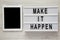 Lightbox with text `Make it happen`, tablet with blank screen on a white wooden background, top view. From above, flat lay,