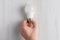 Lightbulb lying on white background and hand holding it b