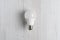 Lightbulb lying on white background and hand holding it b