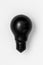 Lightbulb painted with black matte paint on white background