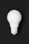 Lightbulb painted in white matte paint on black background