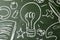 Lightbulb and symbols drawn on a chalkboard, copy space