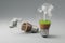 lightbulbs with minature wind turbine and coal-fired power station inside green soil and clouds pollution and smoke renewable