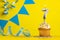 Lighted birthday candle number 7 - Yellow background with blue pennants