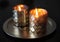 Lighted candles in golden candlesticks on a round gold tray