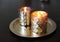 Lighted candles in golden candlesticks on a round gold tray