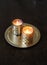 Lighted candles in golden candlesticks on a round gold tray