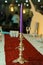 lighted candles on the table in restaurant . Pastel purple candle in antique brass candelabrum or candlestick on blur background
