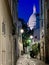 The lighted dome of Sacre Coeur viewed from an alley in nighttime Montmartre, Paris