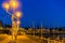 Lighted lampposts at night in the harbor of blankenberge, popular city in belgium, city architecture in the evening