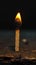 Lighted matchstick rests on a textured brown wooden surface