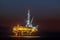 Lighted offshore oil platform at dusk