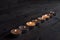 Lighted small candles laid out in a row on a wooden table. Texture. Symbol. Holidays love day