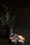 Lighted small candles laid out in a row on a wooden table. Texture. Symbol. Vase with green branches. Still life