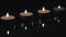 Lighted small candles with reflections in a dark background