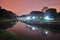 Lighted walkway alongside the river at night