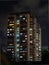 Lighted windows of homes of an HDB high-rise apartment block at night