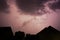 Lightening bolt over houses in the middle of a storm