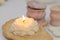The lighter ignites a candle, light a candle hand with match sets fire to scented pink wax candle on a gray background