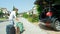 Lighthearted young man whistling while packing luggage into his big black SUV.