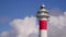 Lighthouse against the background of fast-moving white clouds