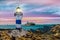 Lighthouse against the background of the sunset landscape. Reference point in maritime navigation