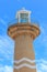 Lighthouse against cloudy blue sky.