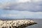 Lighthouse on an artificial breakwater on the coast of Madeira on a cloudy summer day.