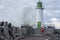 Lighthouse in Baltic sea near port of Ventspils and high  waves above breakwater