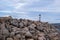 Lighthouse beacon on breakwater, close up view of rocky wall at harbor entry of Greek island