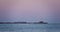 Lighthouse beacon, sailing cargo ship and rising full moon over sea horizon video 4K