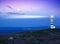 Lighthouse beaming light ray over stormy clouds