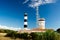 Lighthouse with blue sky and summer clouds and terracotta roof top in chassiron, Oleron Island, France