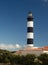 Lighthouse with blue sky and summer clouds and terracotta roof top in chassiron, Oleron Island, France