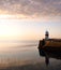 Lighthouse on breakwater wall with calm sea