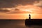 Lighthouse on breakwater wall during sunrise
