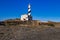 The lighthouse at Cape Favaritx amid dark slate rock, Menorca, Spain