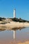 The lighthouse of the Cape of Trafalgar reflected in the water, in the coasts of the south of Spain