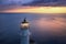 Lighthouse at colorful sunset in summer. Aerial view from drone