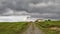 Lighthouse with dark clouds and house landscape