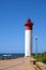 Lighthouse at End Of Paved Walkway at Beach