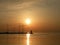 Lighthouse at the end of the pier of stones, sunset over the Adriatic Sea, Croatia, Europe.Orange, calm sea, silhouette, reflectio