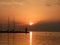 Lighthouse at the end of the pier of stones, sunset over the Adriatic Sea, Croatia, Europe.Orange, calm sea, silhouette, reflectio