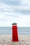 Lighthouse figure on the beach in the evening