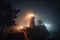 lighthouse on a foggy night, with mist swirling around the tower